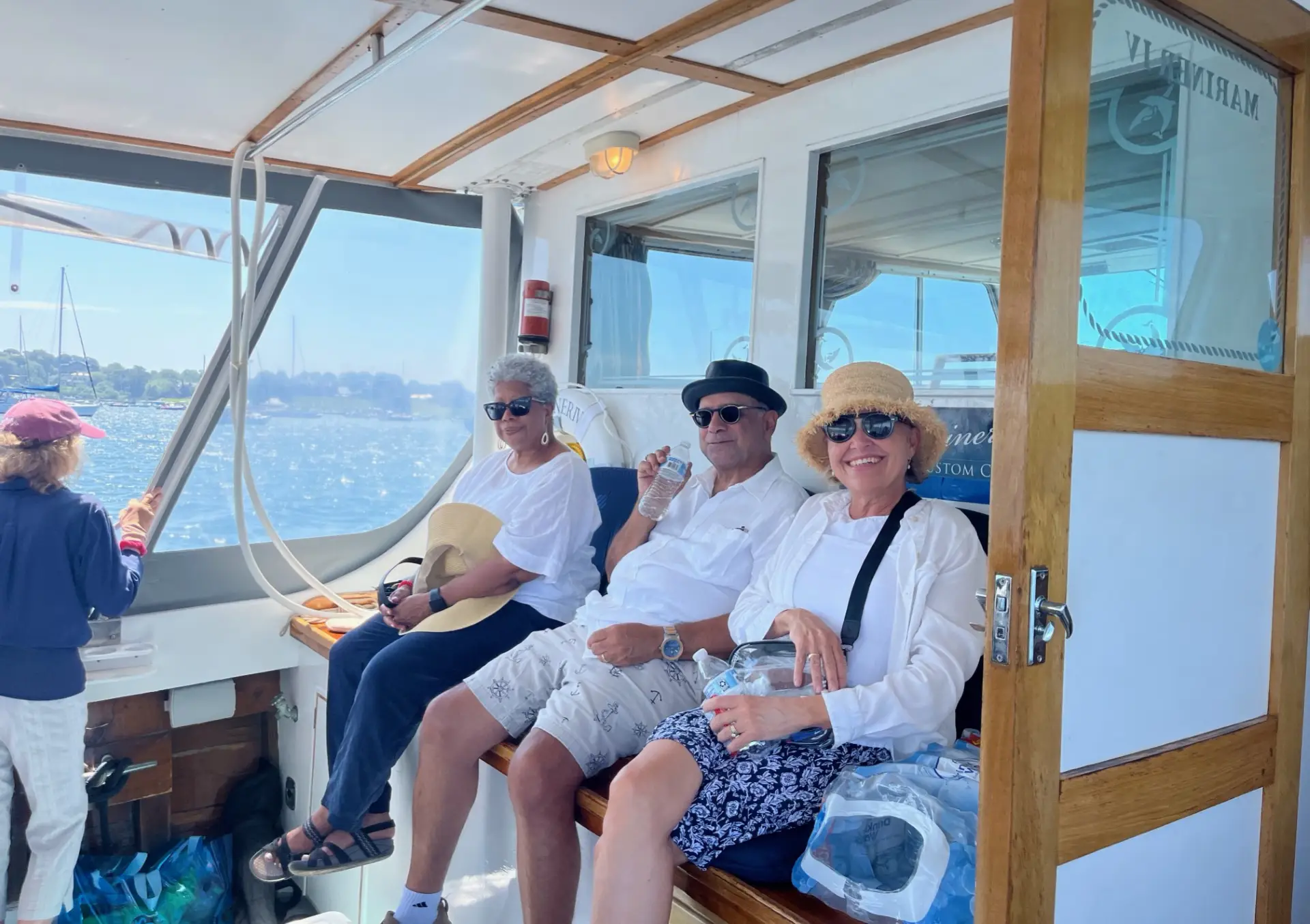 Three people sitting on a boat in the water.