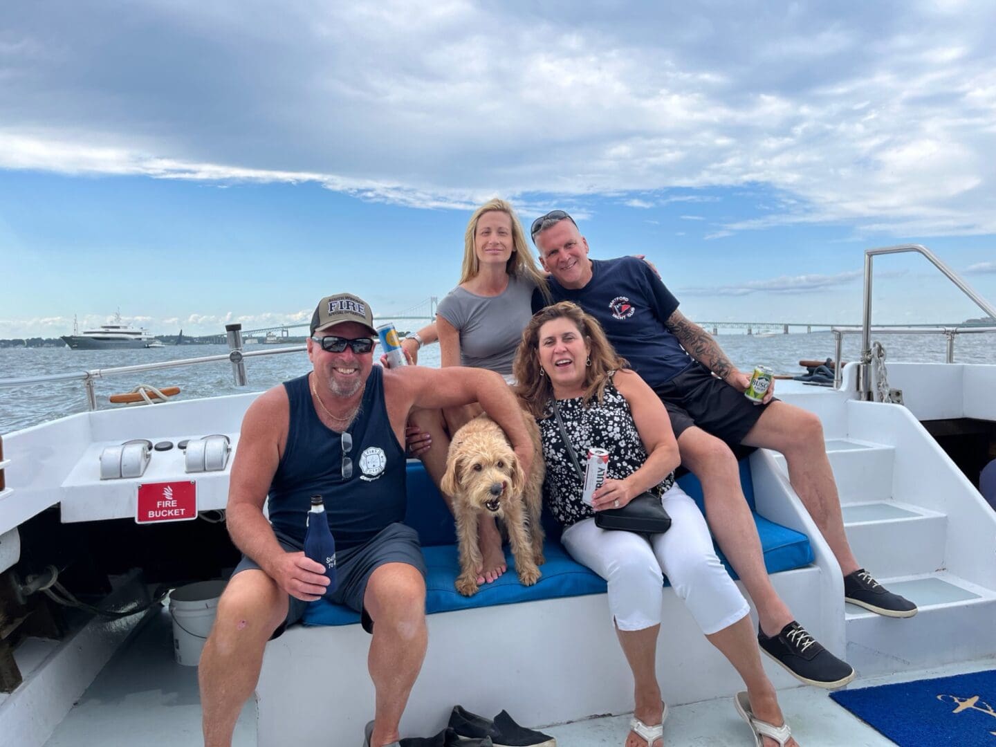 A group of people and their dog on the boat.