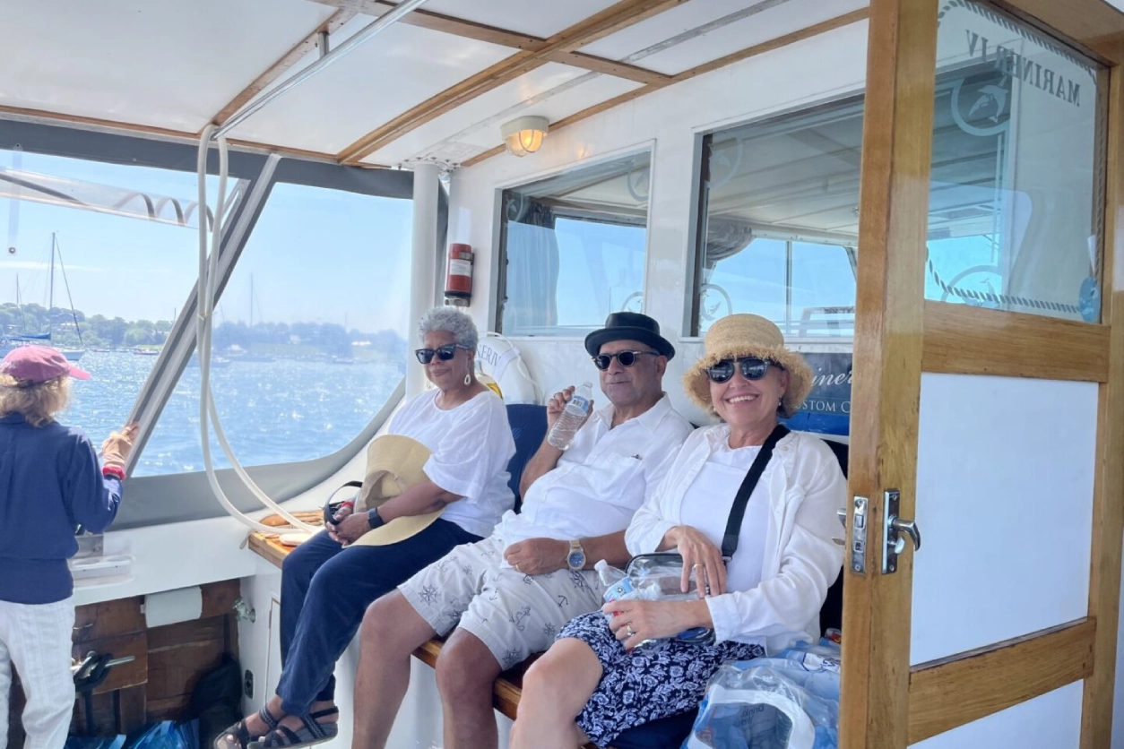 Three people sitting on a boat in the water.