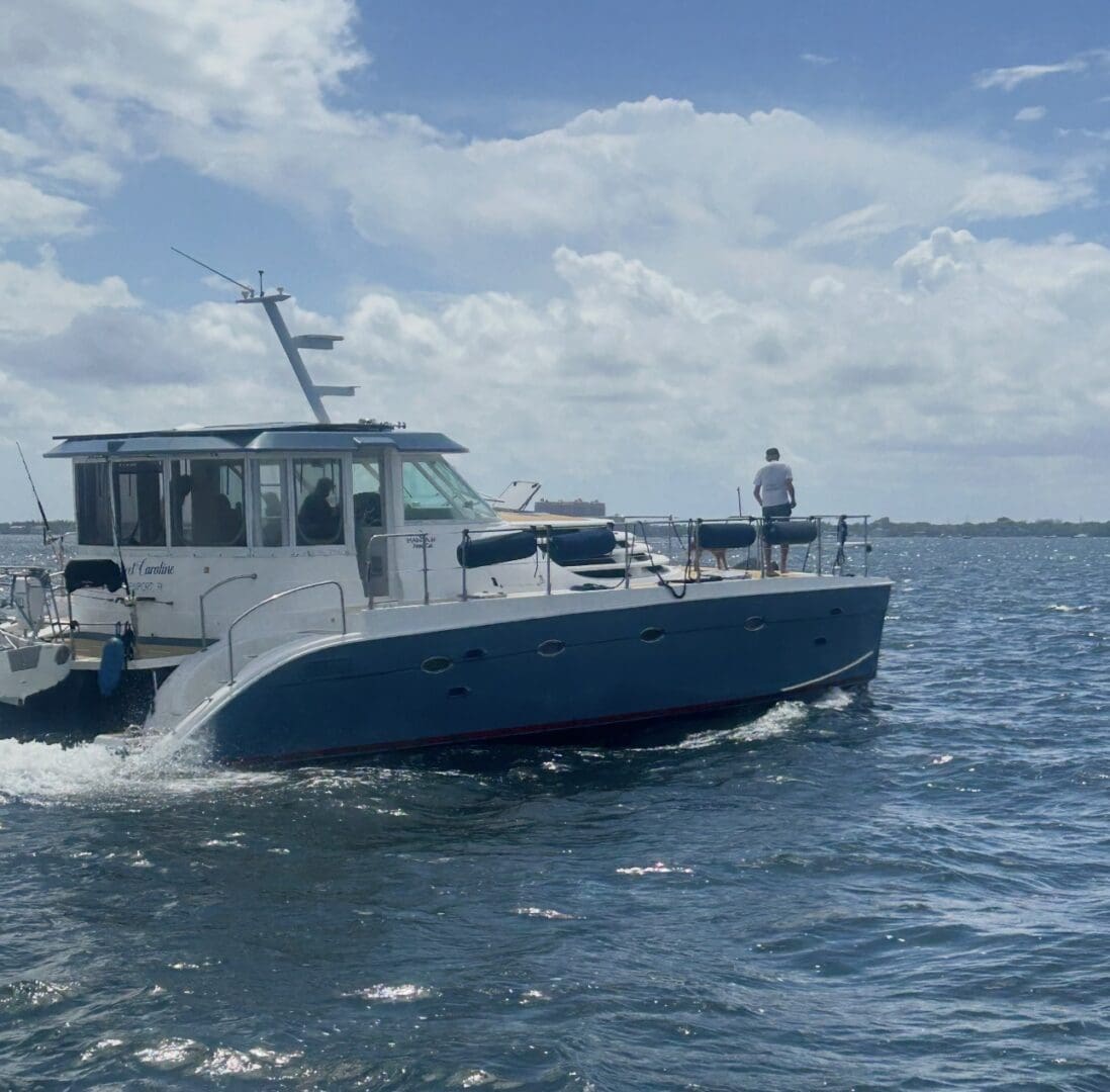 Motor yacht with person cruising on blue water