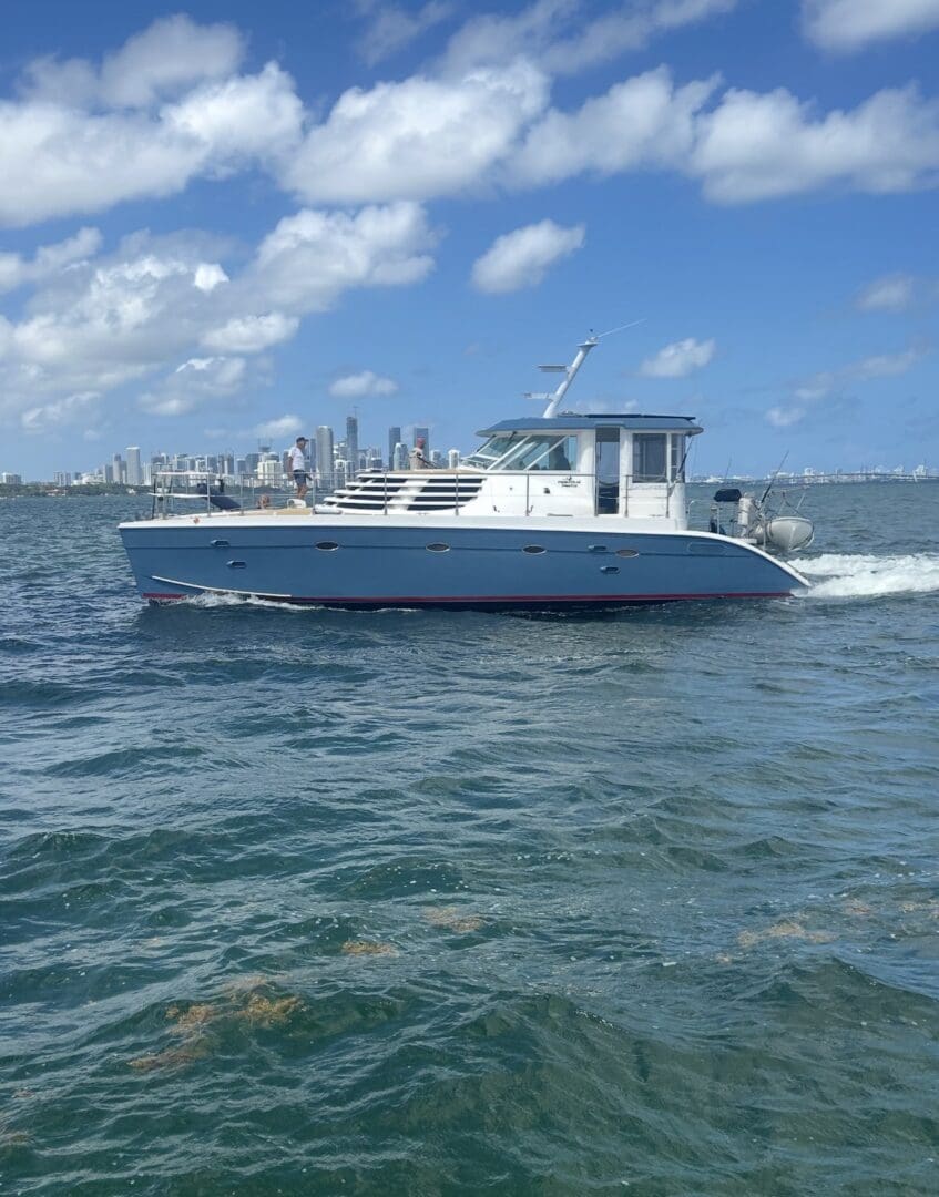 Motorboat cruising near city skyline under blue sky